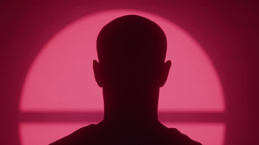 Silhouette of a person facing a screen displaying various signs