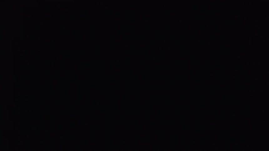 Man in a dark room with flashing red lights using virtual reality glasses