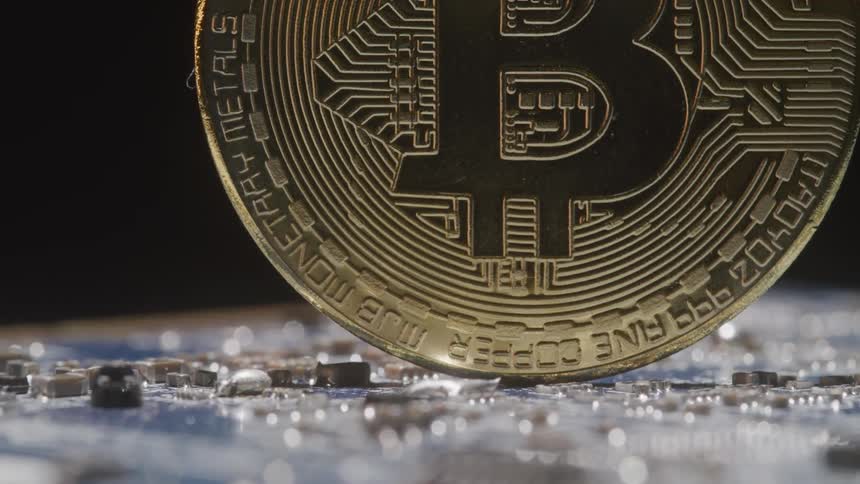 A coin standing on its edge on a circuit board that looks like jewels