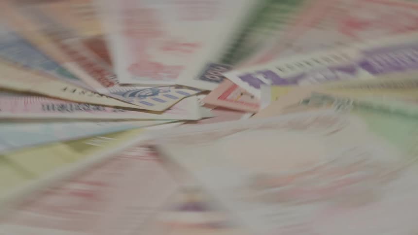 Paper money fans out into a circle on a rotating surface