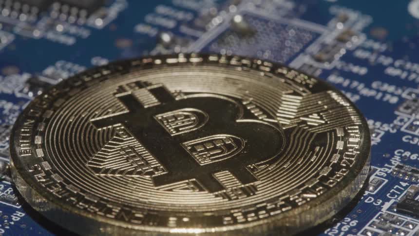 A bitcoin is on top of the computer board