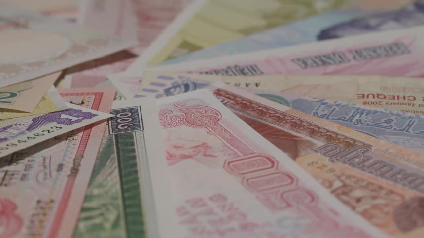Close up of various paper currencies arranged in a circular pattern on a surface