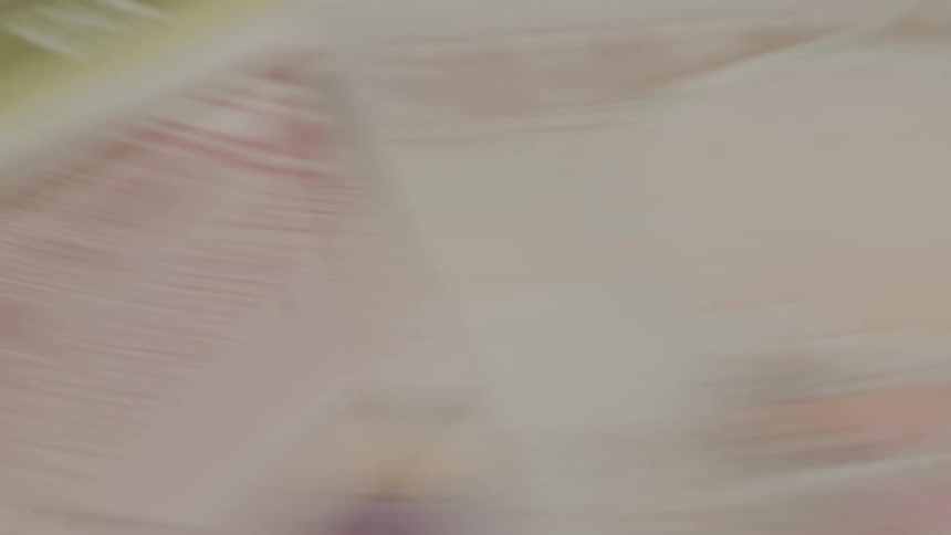 A closeup of paper currency spinning in an abstract swirl of color and motion blur