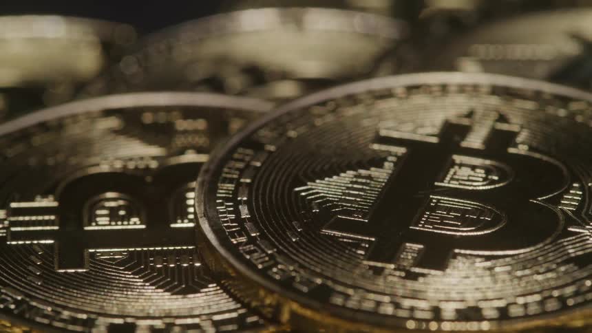 A stack of coins with a bitcoin logo are on display