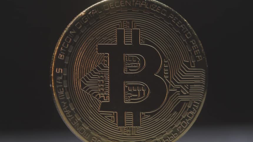 Close up of a bitcoin currency spinning vertically on a surface