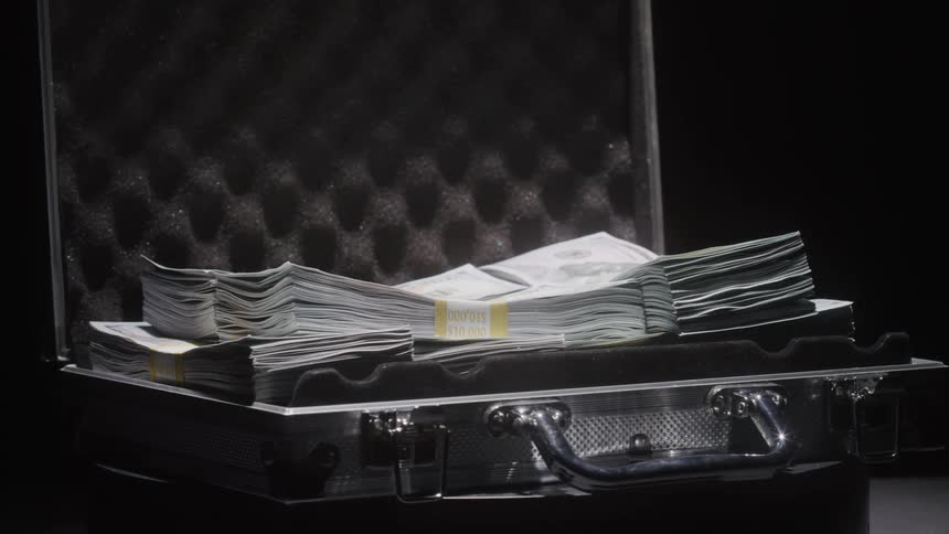 Bundles of paper money lie in an open briefcase