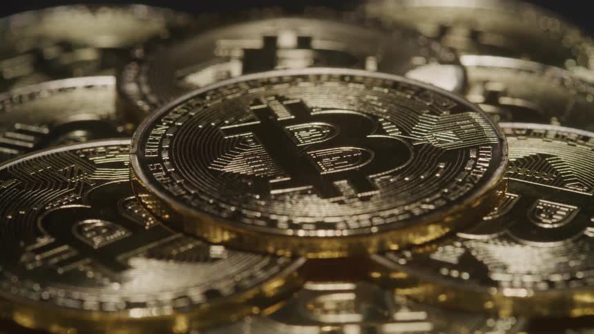 A bunch of stacked coins are spinning close up