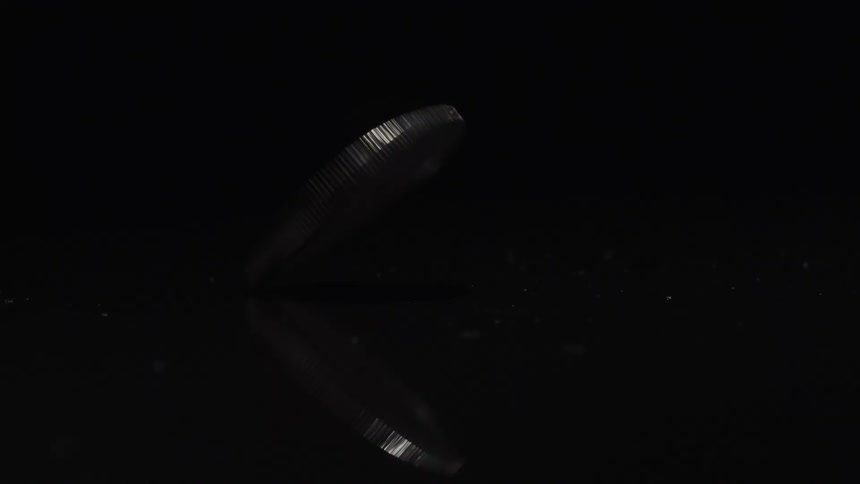 The coin is spinning and reflecting light