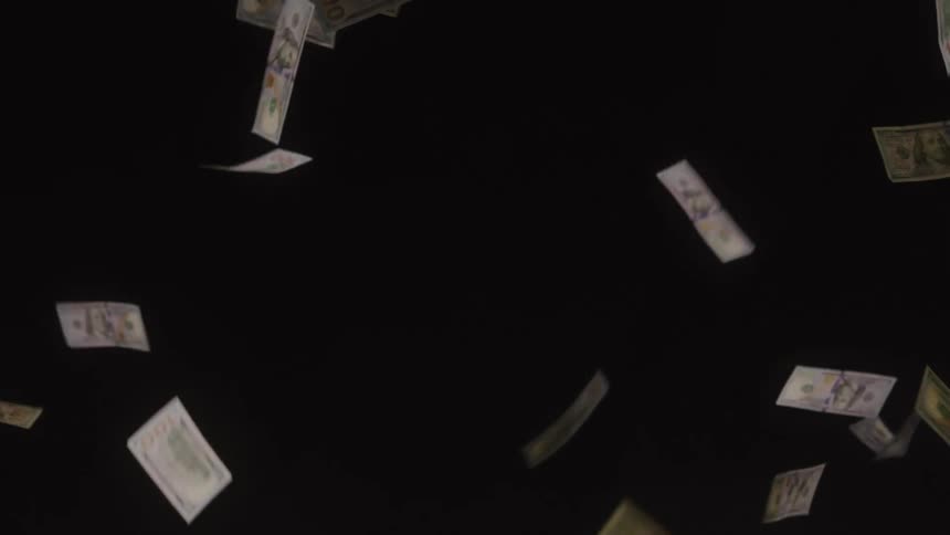 Multiple one hundred dollar bills flutter and fall downward in slow motion against a solid black background