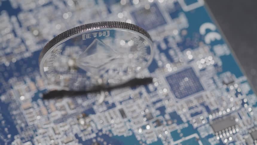 Ethereum coin stands upright on a computer circuit board