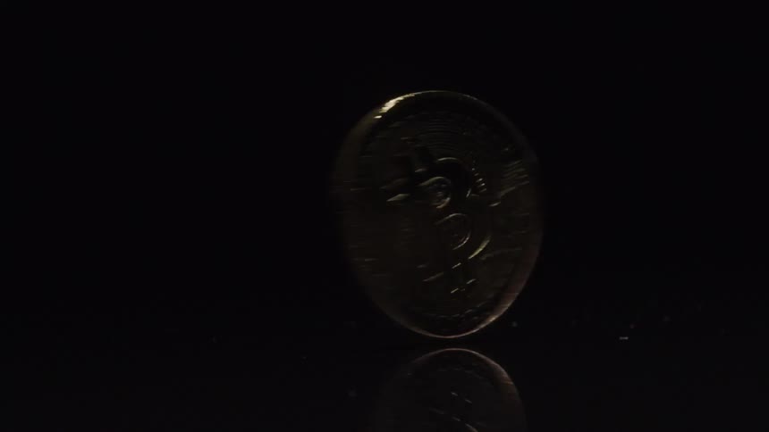 A coin spinning on a surface with a black background