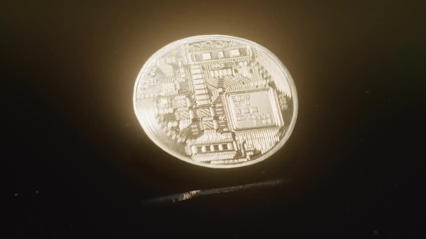A rotating coin with a circuitlike design spins against a black background