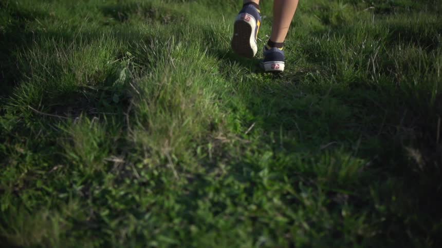 Feet walking through grassy area