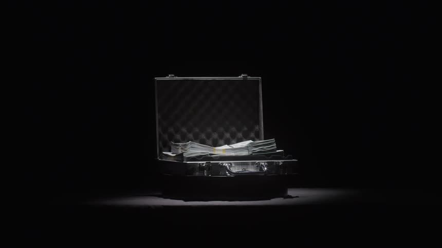An open suitcase filled with stacks of money slowly rotates