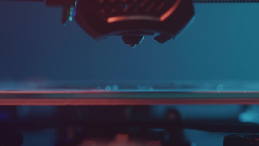 A 3d printer slowly moves downward in preparation of printing an object