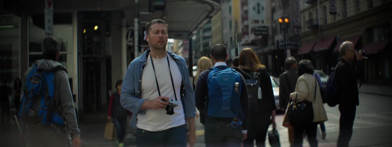 People walk down a busy city street