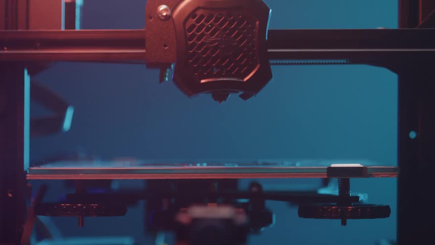 A 3d printer device lowers its nozzle to the build platform initiating a printing session