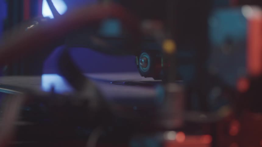 The nozzle of a 3d printer meticulously builds a small object layer by layer