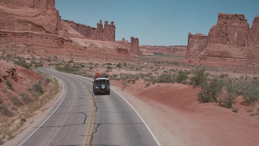 Jeep driving on a highway through a canyon