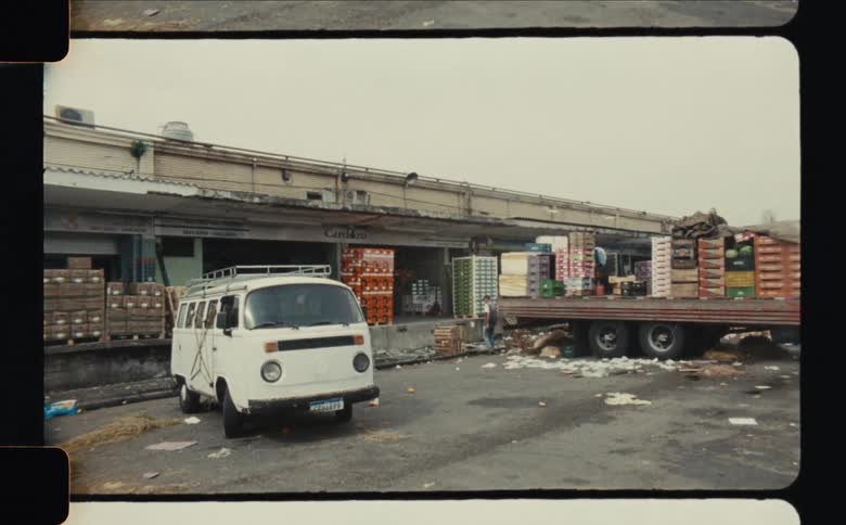 Workers move around a truck while loading the vehicle at a warehouse