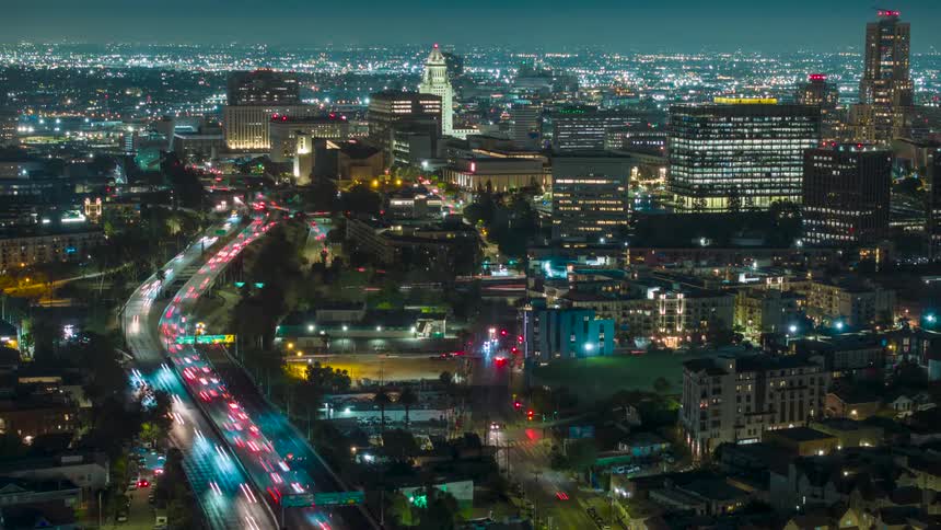 Aerial view of a lit up city at night with heavy traffic
