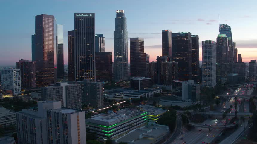 Aerial of cars driving on a highway in downtown Los Angeles at sunset