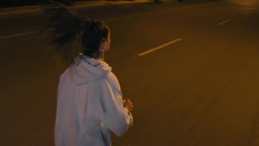 The woman is running in the street at night