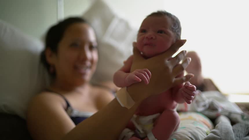 A woman holds her newborn