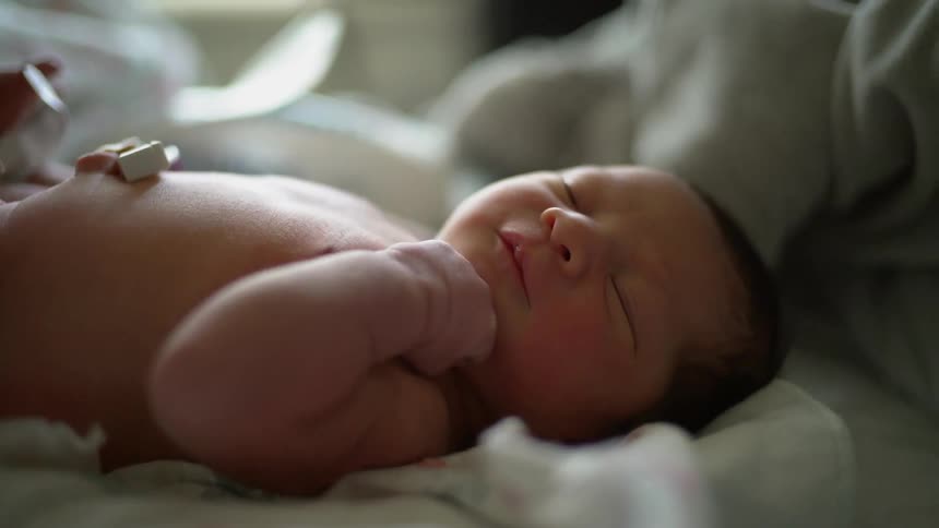 A person changes a newborn's diaper