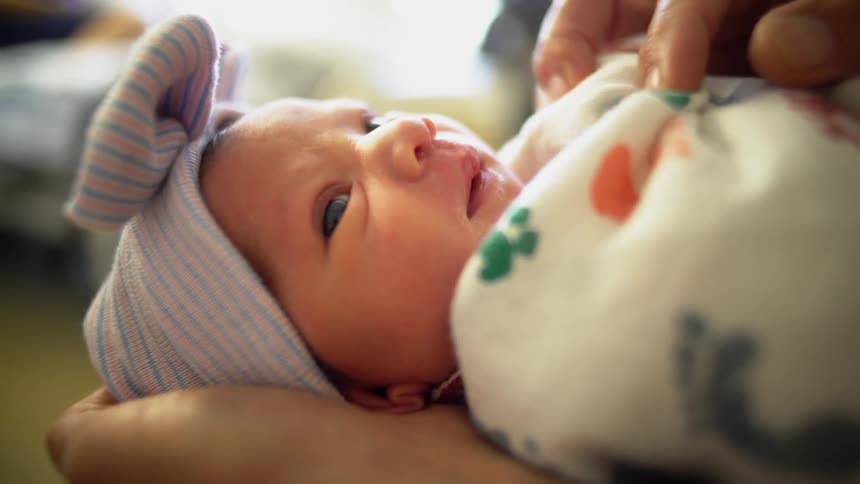 A baby is being rocked in a blanket