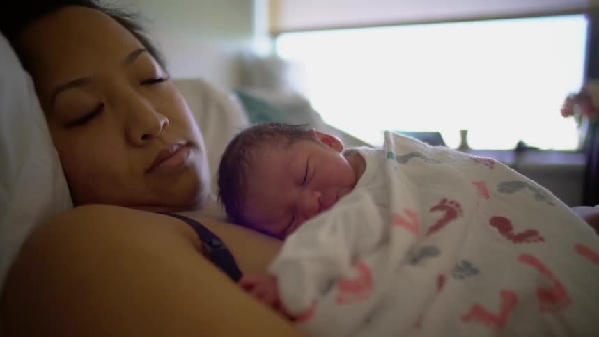 A mother lays with her infant on her chest