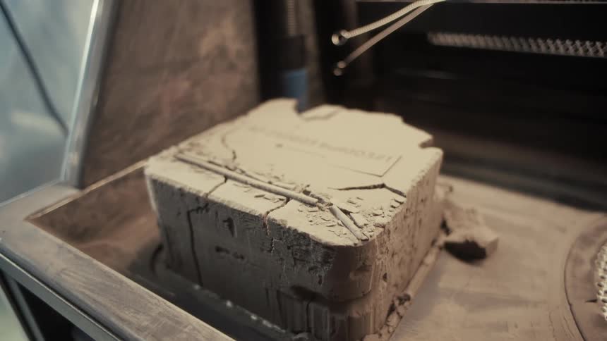 Beige mass sits in a machine in a workshop