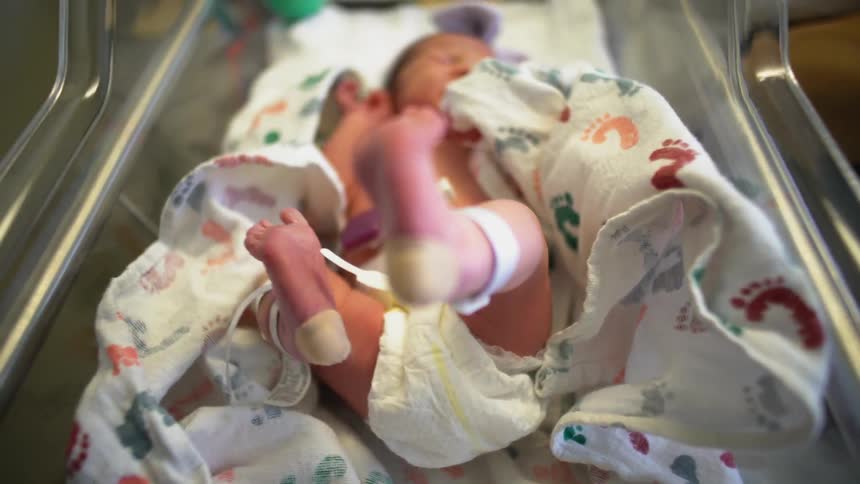 A baby cries and kicks its feet