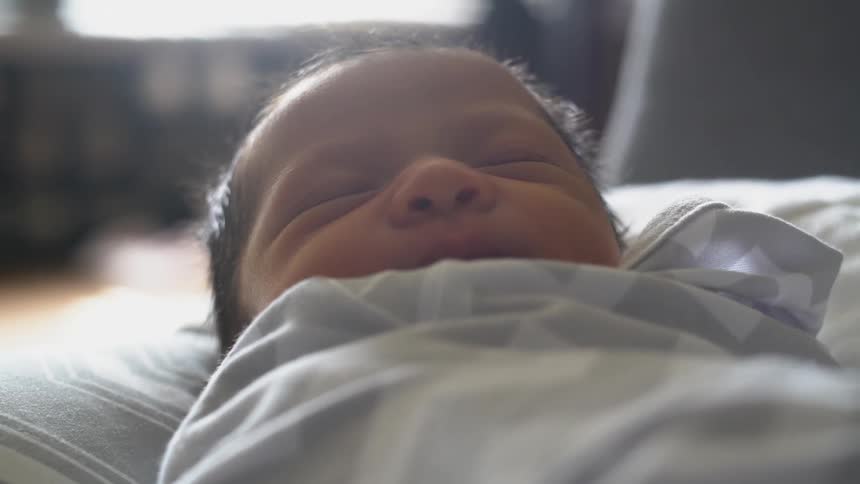 An infant is swaddled in a blanket