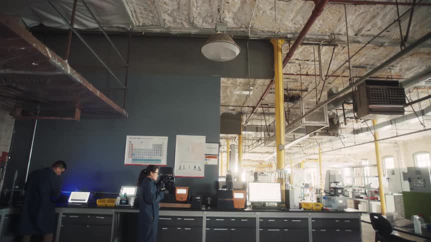 Coworkers work at separate stations in a manufacturing plant during the daytime