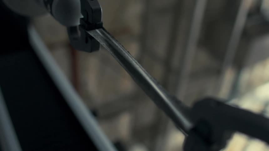Robot hands manipulate a metallic object in a factory