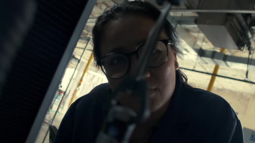 A factory worker examines one of the machines