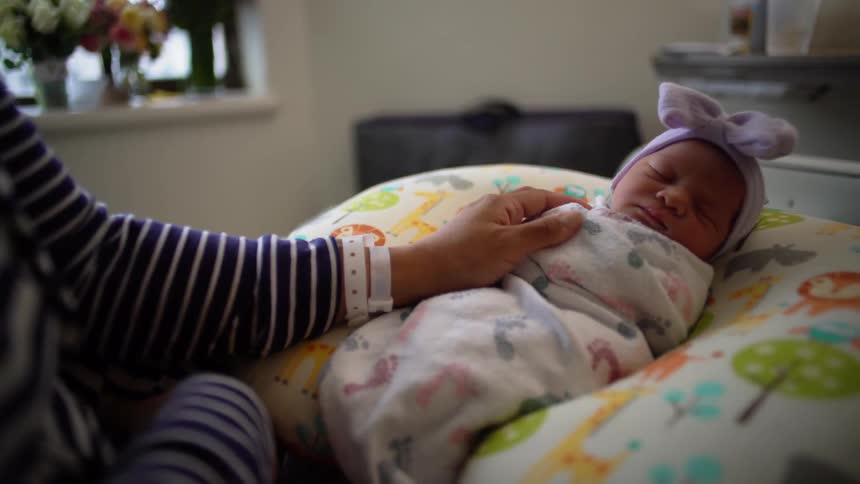 A baby is tightly wrapped in a blanket sleeping
