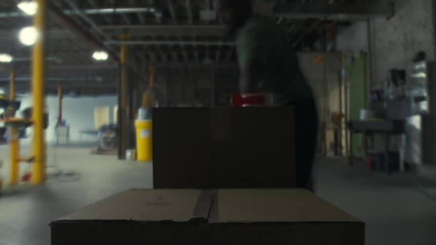 Worker packs boxes and moves them in the warehouse