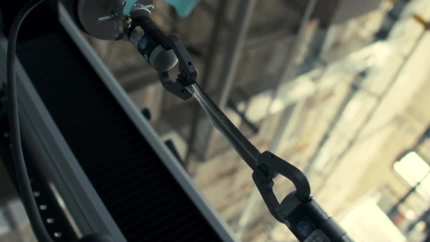 Two robotic hands stretch the tape