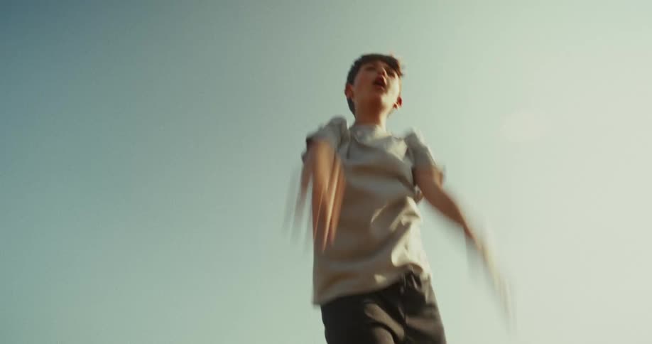 A boy is throwing a soccer ball and catching it outdoors