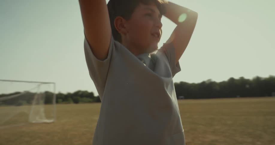 A boy is throwing and catching a soccer ball in the air