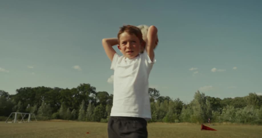 Two kids at a park throwing a soccer ball back and forth