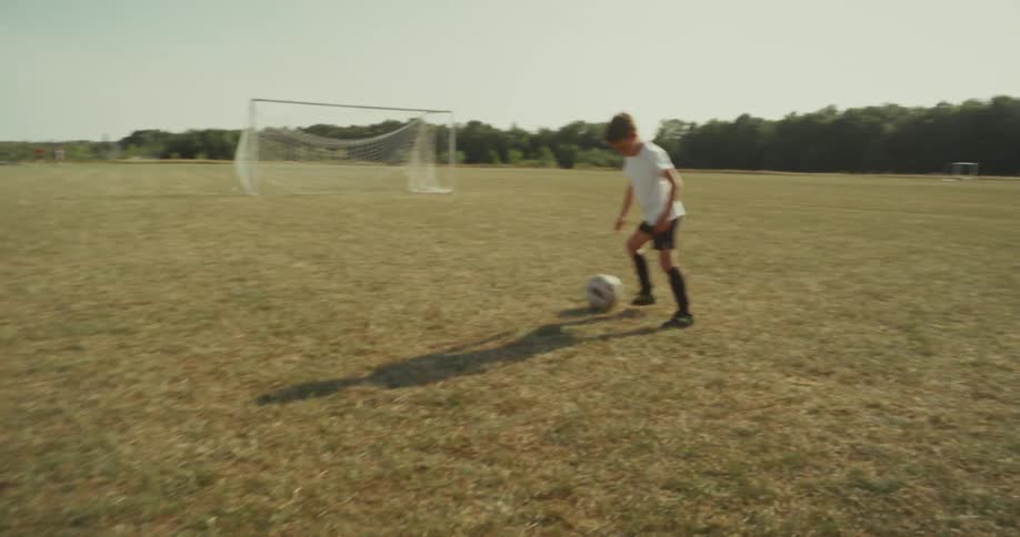 Two kids playing a game of soccer at a park