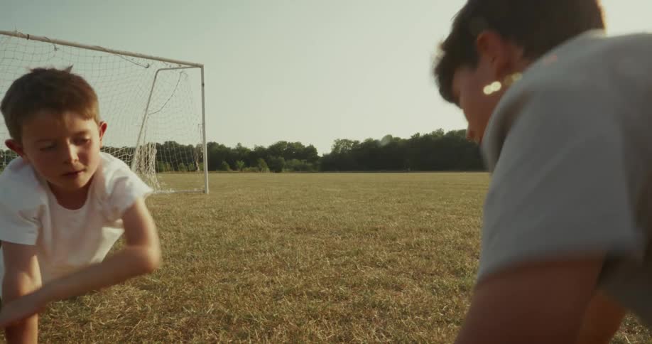 Two boy friends in a field doing pushups and touching palms to each other