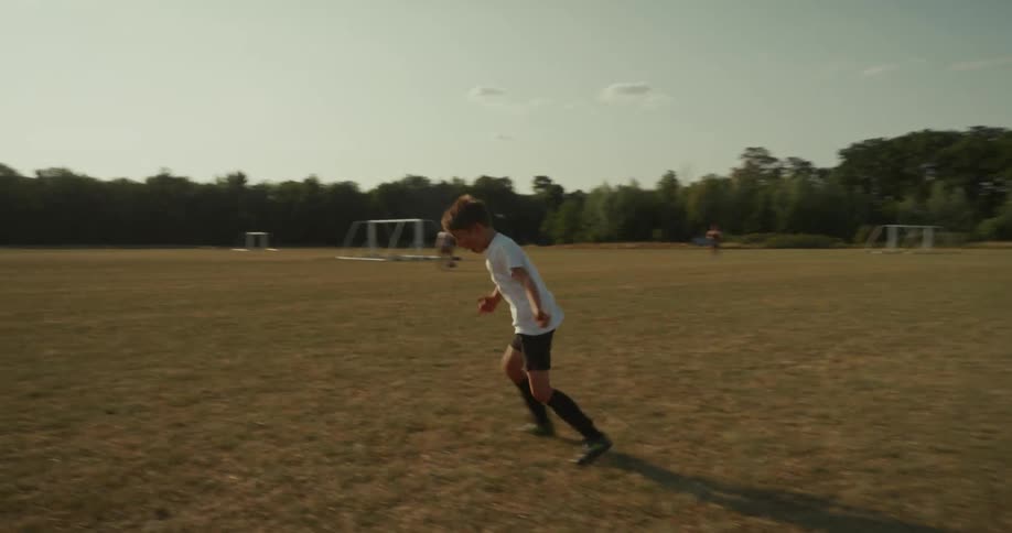 Boy kicking a soccer ball and celebrating happily