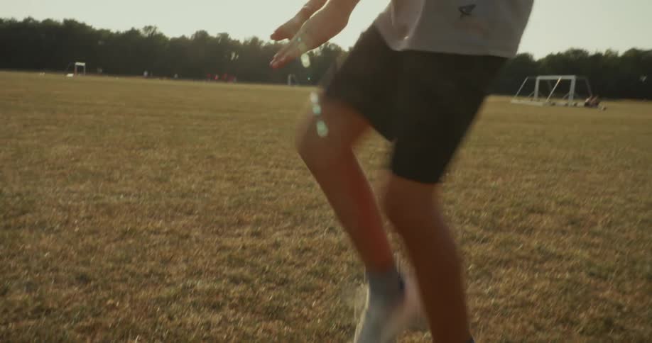 A child jogging in place on a field staying active while remaining in one spot