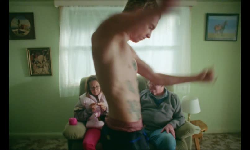 Son dancing wildly as parents watch calmly from couch