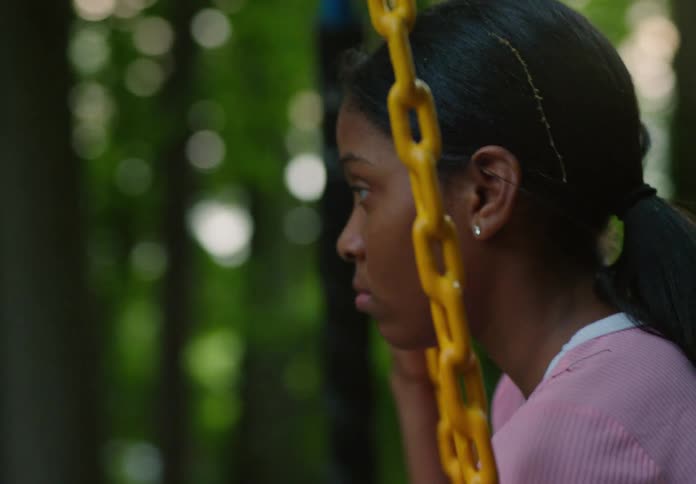 A girl sits on a swing in the park