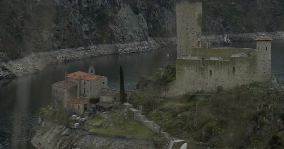 Old stone buildings sit perched on a cliffside